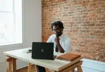 a man sitting at a table in front of a laptop