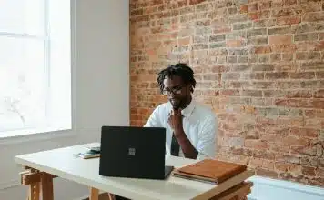 a man sitting at a table in front of a laptop