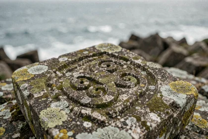 Symbole triskel sculpté en relief sur une pierre de granit ancienne au bord de la côte atlantique